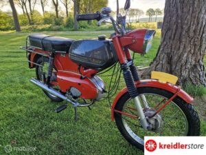 Rode Kreidler floret op grasveld. Je brommer start niet, Kreidlerstore lost het op.